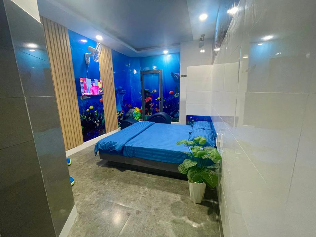 1 dormitorio con 1 cama en una habitación con un acuario en NHÀ NGHỈ K house, en Ben Tre