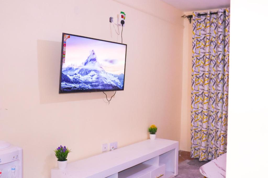 a living room with a tv on the wall at Vush Homes in Nairobi