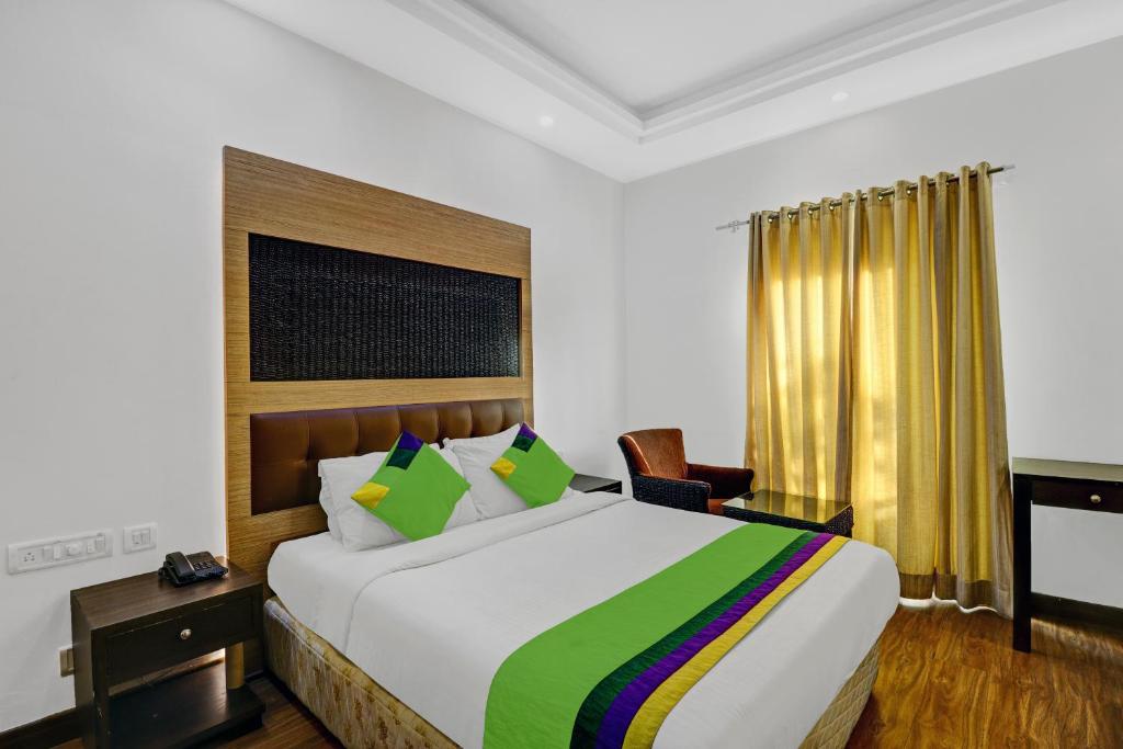 a bedroom with a large bed and a desk at Treebo Trend Elmas Boutique in Bangalore