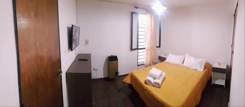 Habitación pequeña con cama y puerta de madera en Alojamiento CBA - B en Córdoba