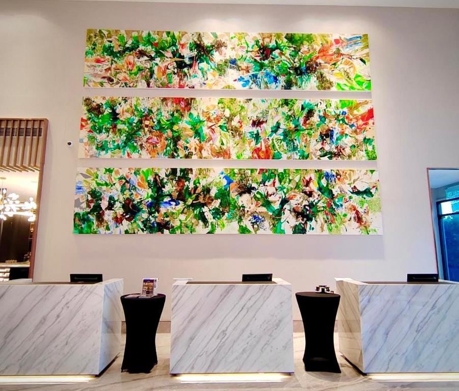 A reception area with marble-look desks and a large abstract triptych.