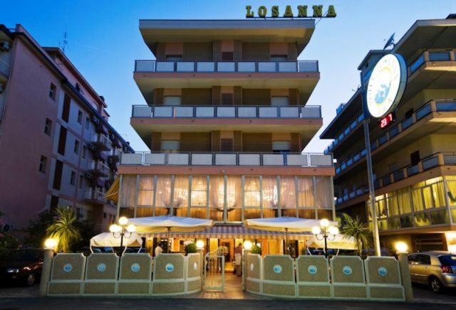 un edificio con un reloj al costado. en Hotel Losanna Cervia, en Cervia