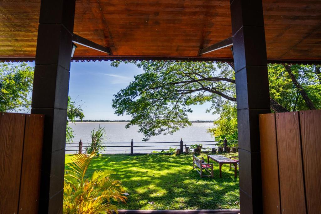 uma vista para a água a partir do alpendre de uma casa em Nakorn River View em Champasak