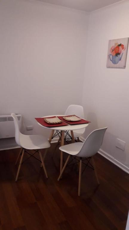 Una mesa y cuatro sillas en una habitación en DEPARTAMENTOS SANTIAGO CENTRO # 5, en Santiago