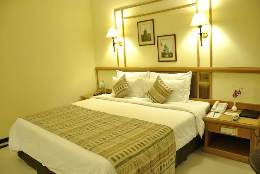 una habitación de hotel con una cama grande y una mesa en Aditya Hometel, en Hyderabad