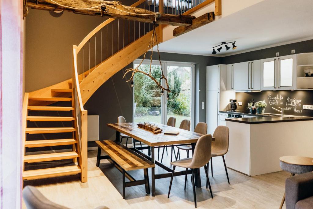 cocina y comedor con mesa de madera y escaleras en Ferienhaus Hünzingen, en Walsrode