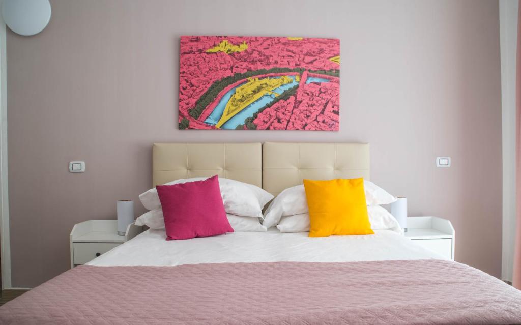 a bedroom with a bed with colorful pillows at Tiber Rooms Testaccio in Rome