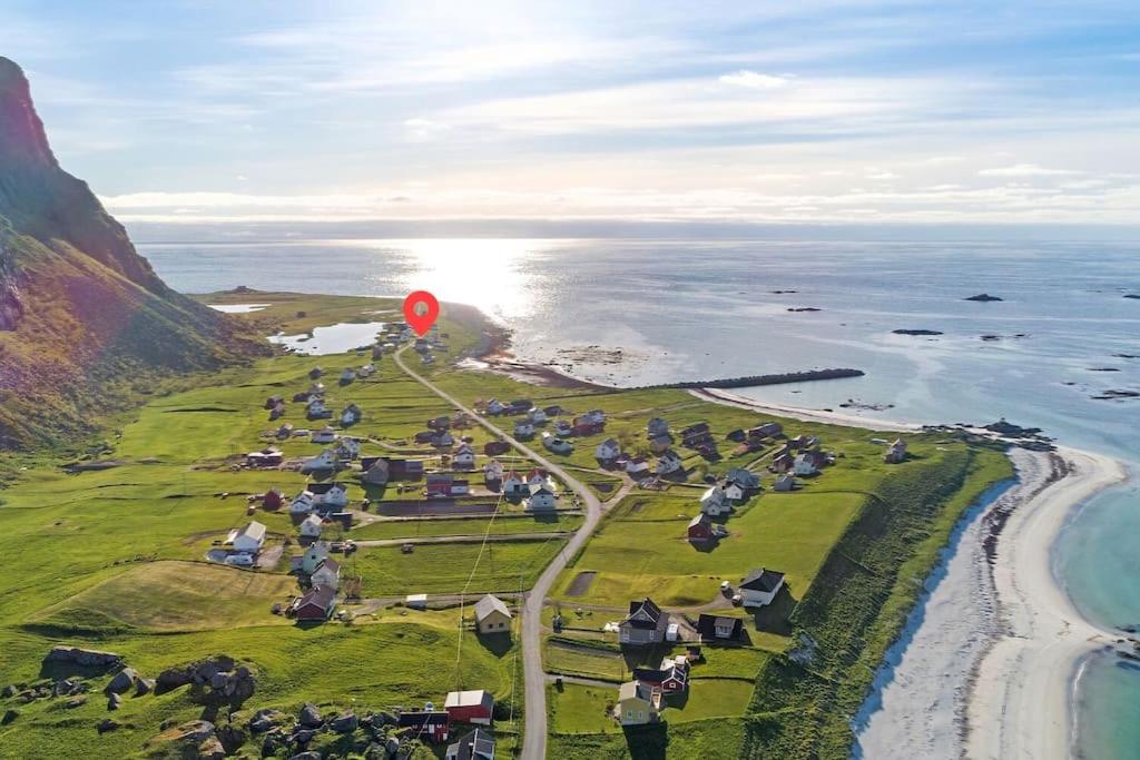 a red balloon is flying over a field next to the ocean at House by the ocean with midnight sun view in Eggum