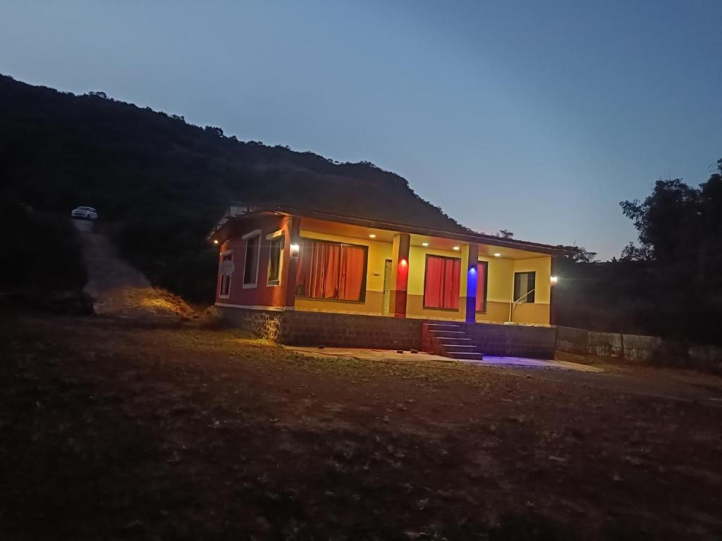a small house at night with the lights on at Vishal lake farm in Lavasa