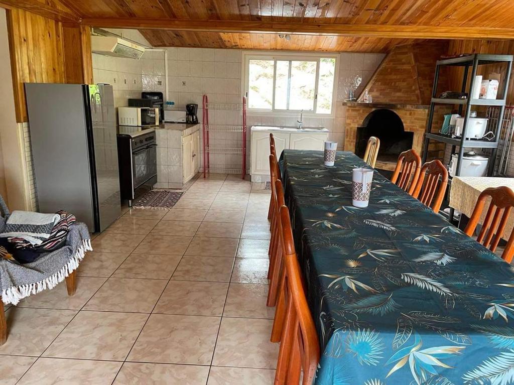 een keuken met een lange tafel in een kamer bij LE VIGNERON in Cilaos