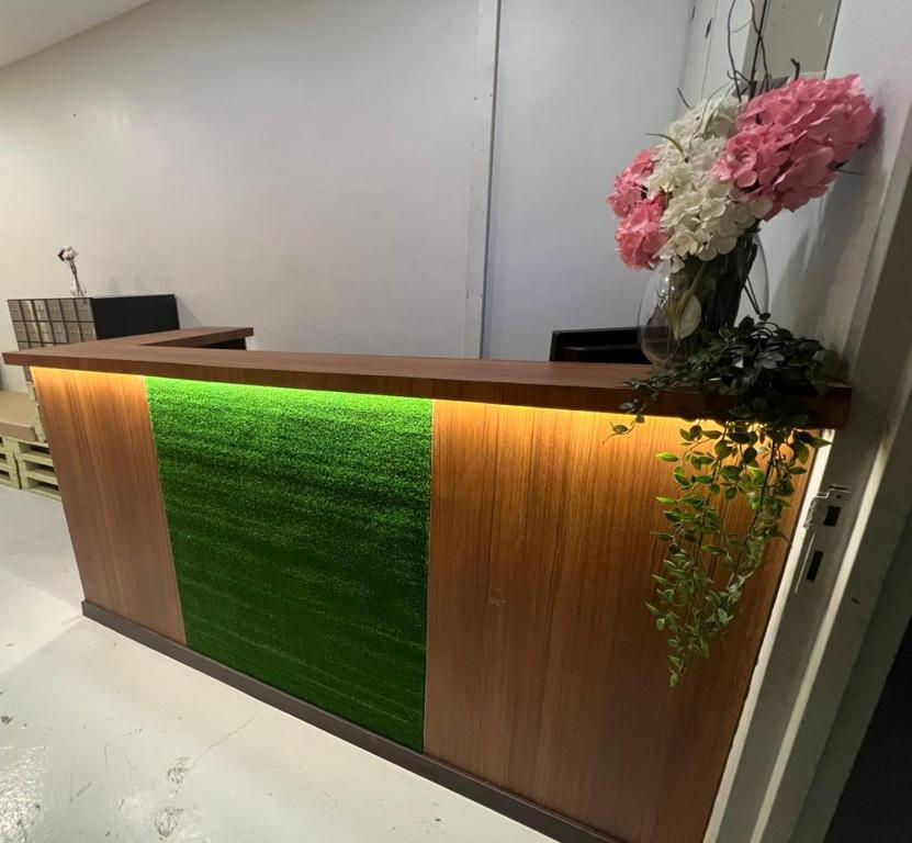 a reception desk with a green stripe on it at MyPods @ Bukit Bintang in Kuala Lumpur