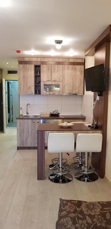 a kitchen with a counter with stools in it at Apartman ML in Raška