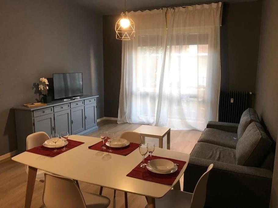 ein Wohnzimmer mit einem Tisch und einem Sofa in der Unterkunft La casa di Anna, appartamento trilocale con balcone e garage in Brescia
