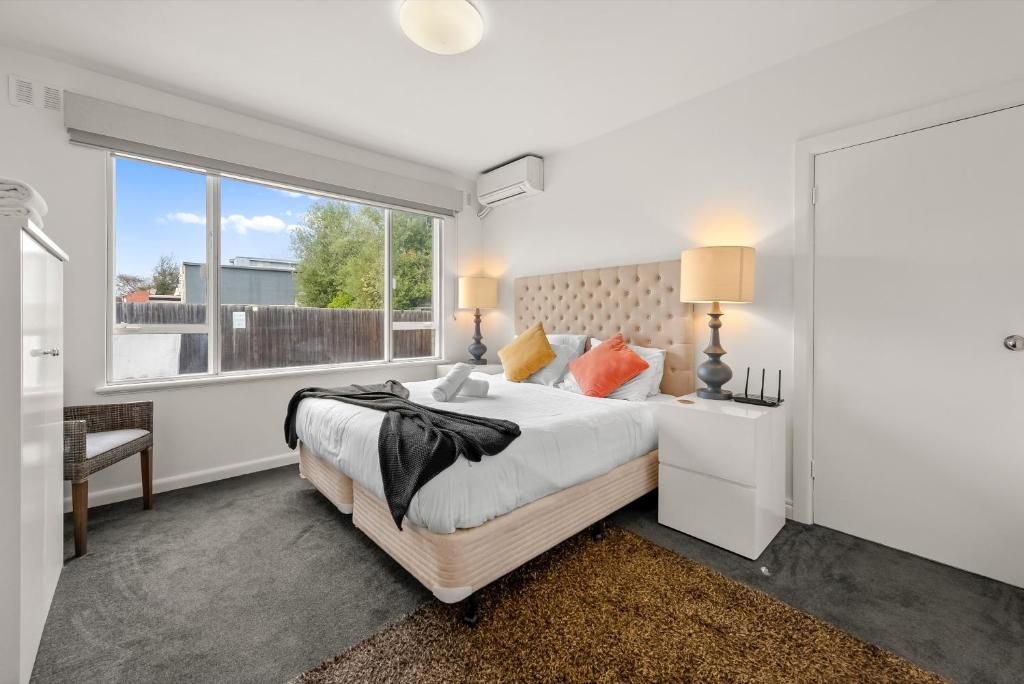 Un dormitorio con una cama grande y una ventana en StayCentral - Brunswick Vibe Parkville, en Melbourne