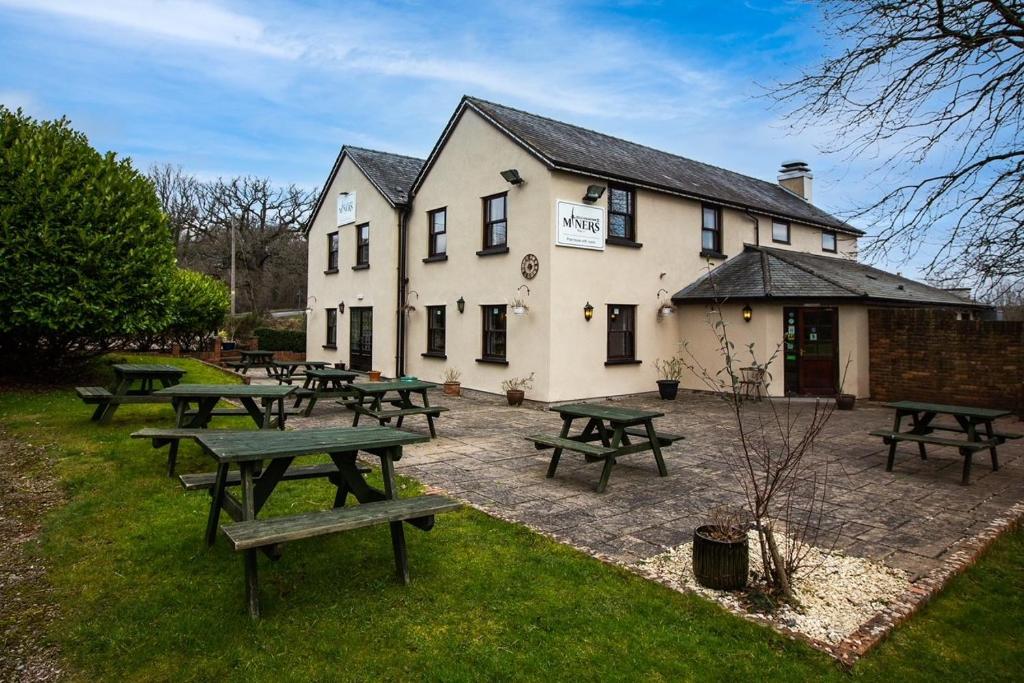 un groupe de tables de pique-nique devant un bâtiment dans l'établissement Wyevalleycateringminers gl16, à Coleford