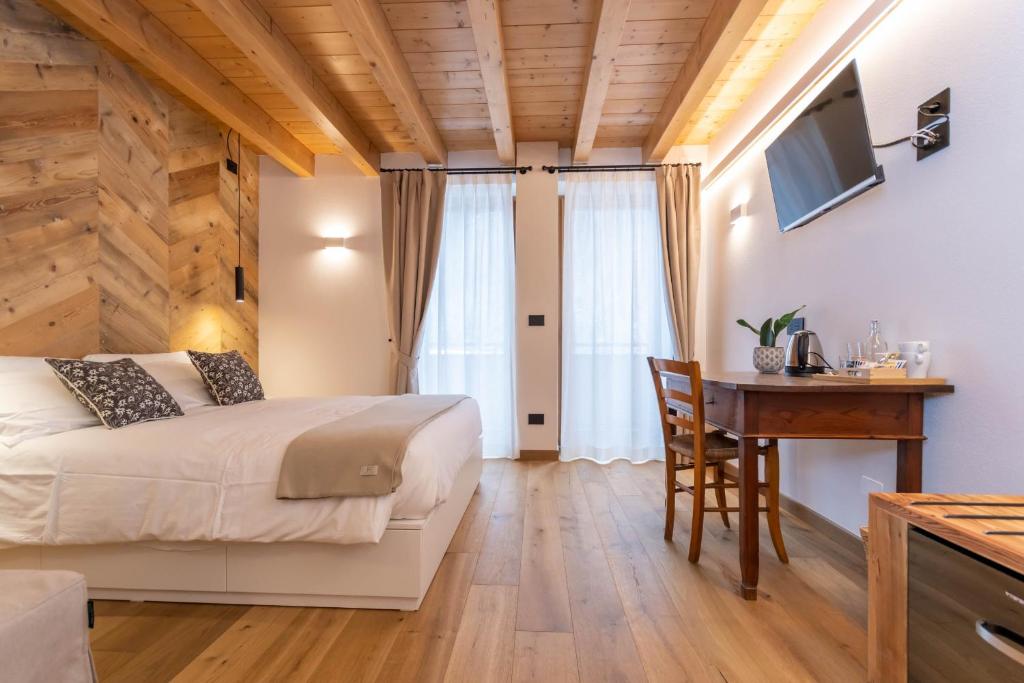 a bedroom with a bed and a desk and a table at B&B El Lares - B&B L'Avez in Canale dʼAgordo