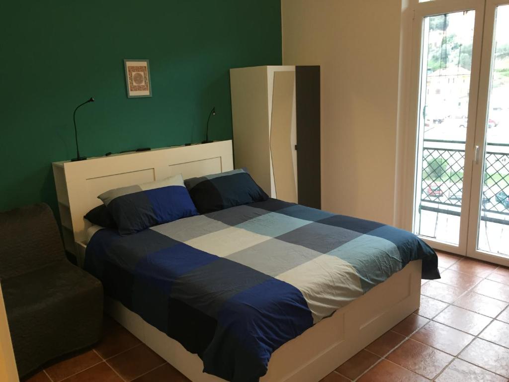 1 dormitorio con 1 cama con edredón azul y blanco en Celtic House B&B, en Varazze