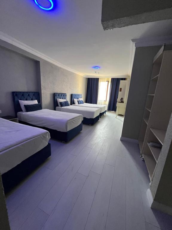 a hotel room with two beds and a room with shelves at Seher HOTEL in Istanbul