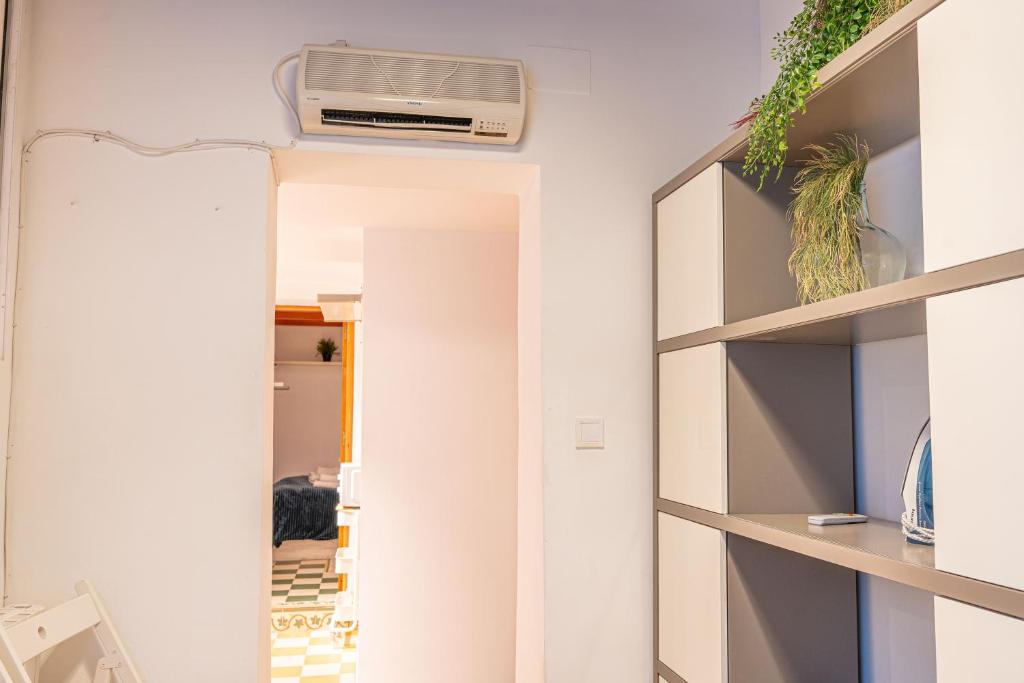 Adorable apartamento en Almagro في مدريد: غرفة بها مرآة وسخان على الحائط