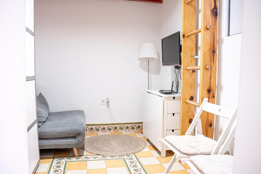 salon z krzesłem i telewizorem w obiekcie Adorable apartamento en Almagro w Madrycie