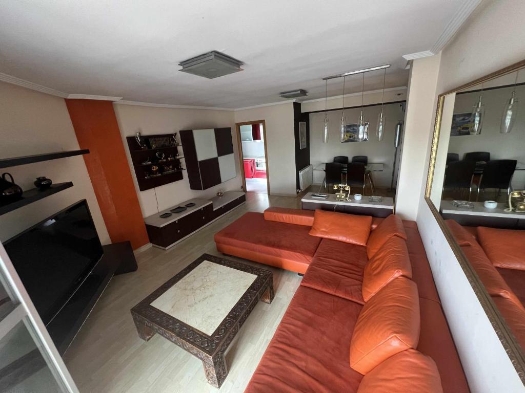 - Vistas a la sala de estar con sofá en MuroHouse Apartamento con piscina Fibra1Gb Wifi Garaje, en Zaragoza