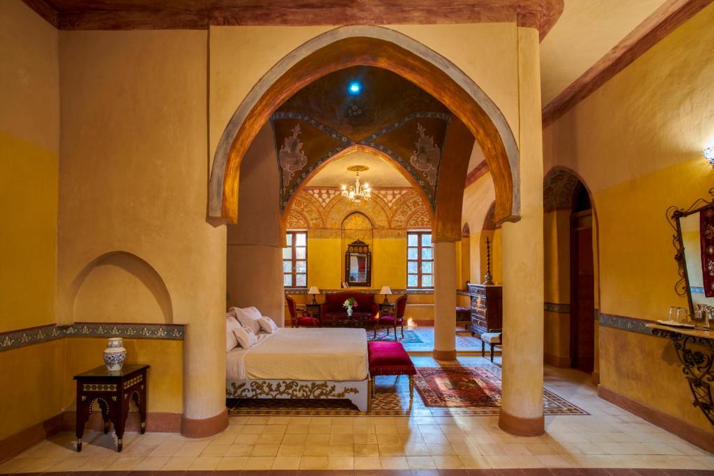ein Schlafzimmer mit einem Bett in einem Zimmer mit einem Torbogen in der Unterkunft Al Moudira Hotel in Luxor