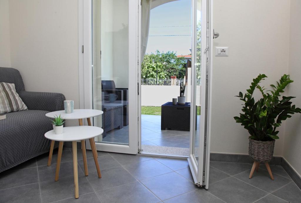 een woonkamer met een deur naar een patio bij Casa Bianca Marea in Santa Maria Navarrese
