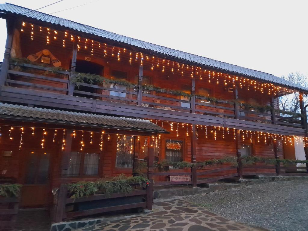 a building with christmas lights on the side of it at Casa de la ferma Mariuca in Berbeşti