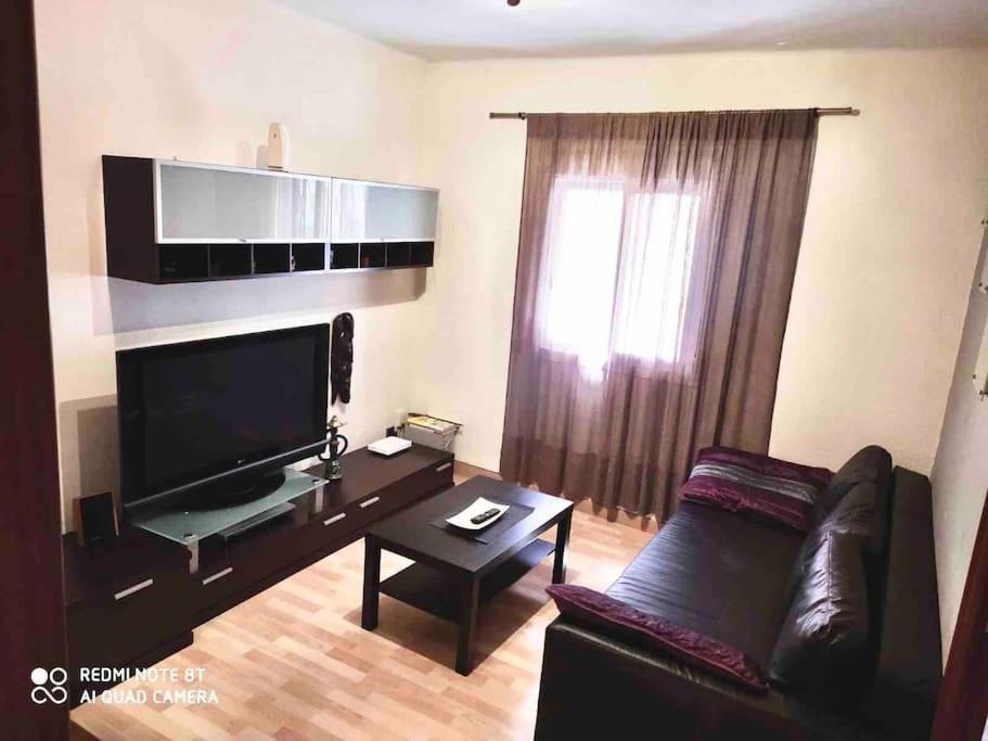 a living room with a couch and a large television at Offer Economic apartment Barcelona in Barcelona