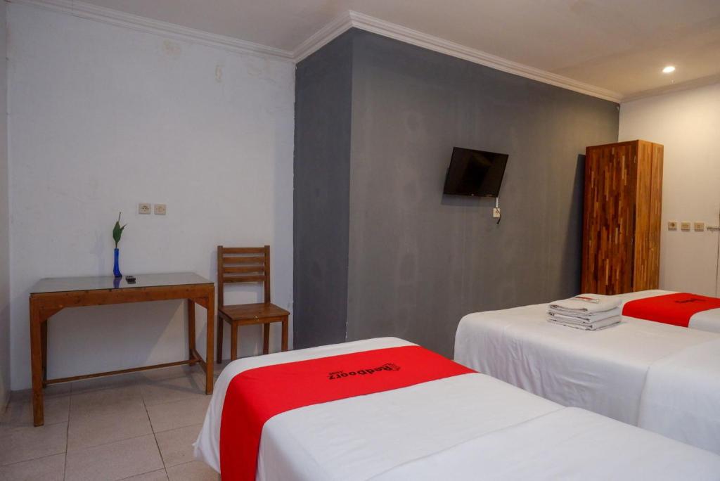 Postel nebo postele na pokoji v ubytování RedDoorz Syariah near Plengkung Gading 2