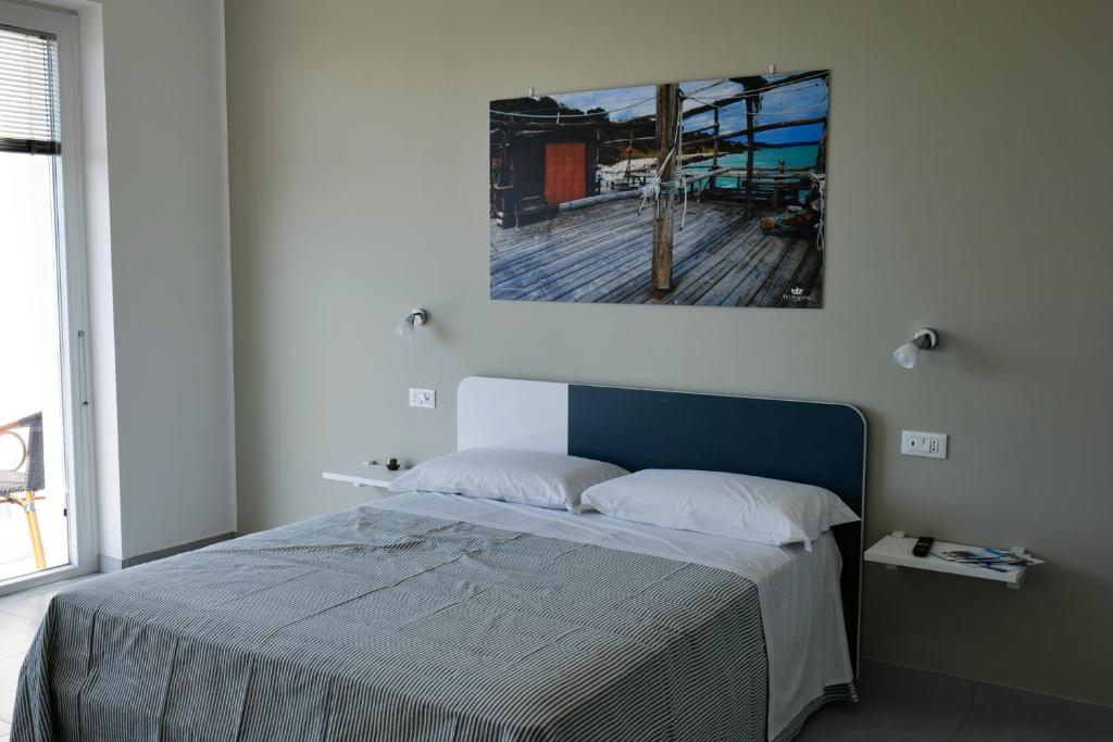 a bedroom with a bed with a painting on the wall at Villa Caravaggio Comfort e Relax in Rocca San Giovanni