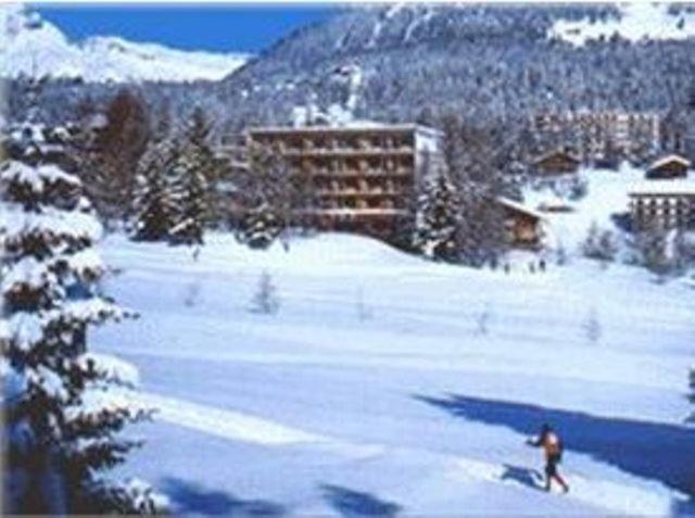a person is skiing on a snow covered slope at Hotel Belmont in Crans-Montana