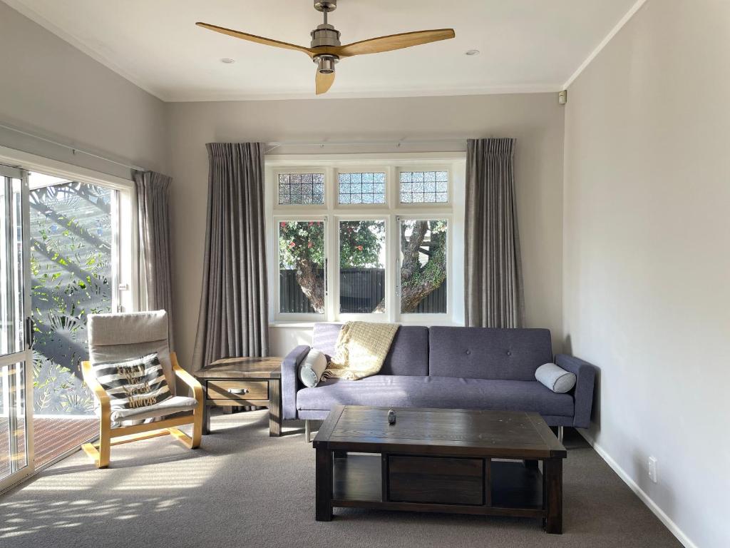 a living room with a blue couch and a chair at Central Petone, lovely 4 bedroom in Lower Hutt