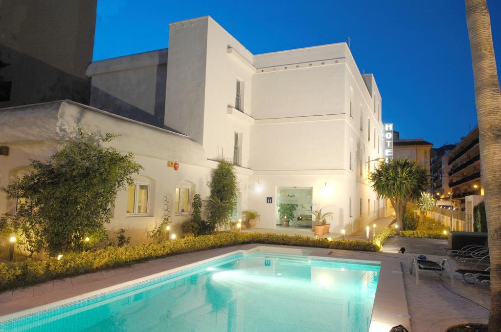 a house with a swimming pool in front of a building at Hotel Bulevard in Benicàssim