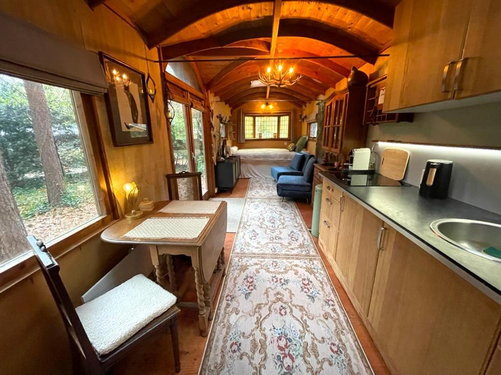 a kitchen and dining area of a tiny house at Pipowagen de Kat in de Hoge Kempen nabij Maastricht in Lanaken
