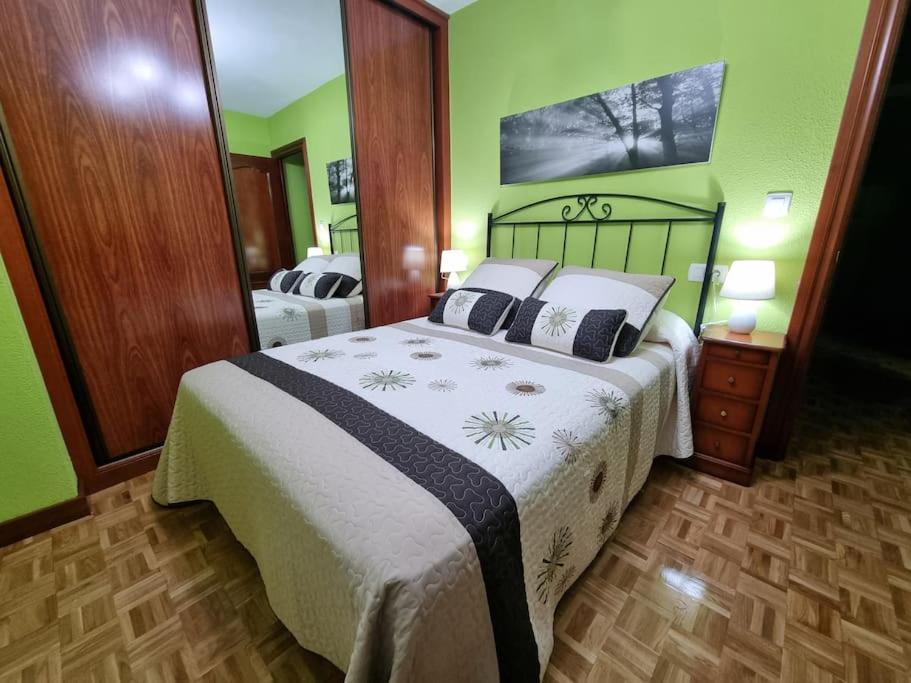 een slaapkamer met een groot bed en een grote spiegel bij 126B Apto Playa - 3 Habitaciones in Gijón