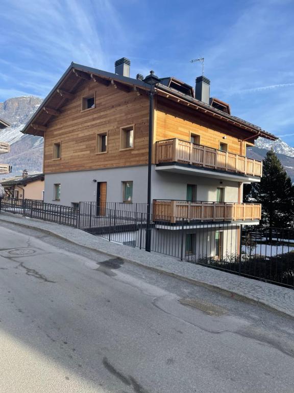 a large wooden house with a balcony on a street at La Casa di Armando in Bormio