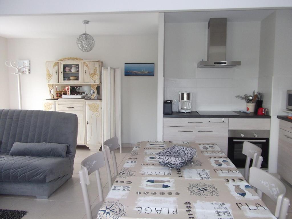 a kitchen and dining room with a table and a couch at Le Logis Des Grenouilles- Gîtes in Lamballe