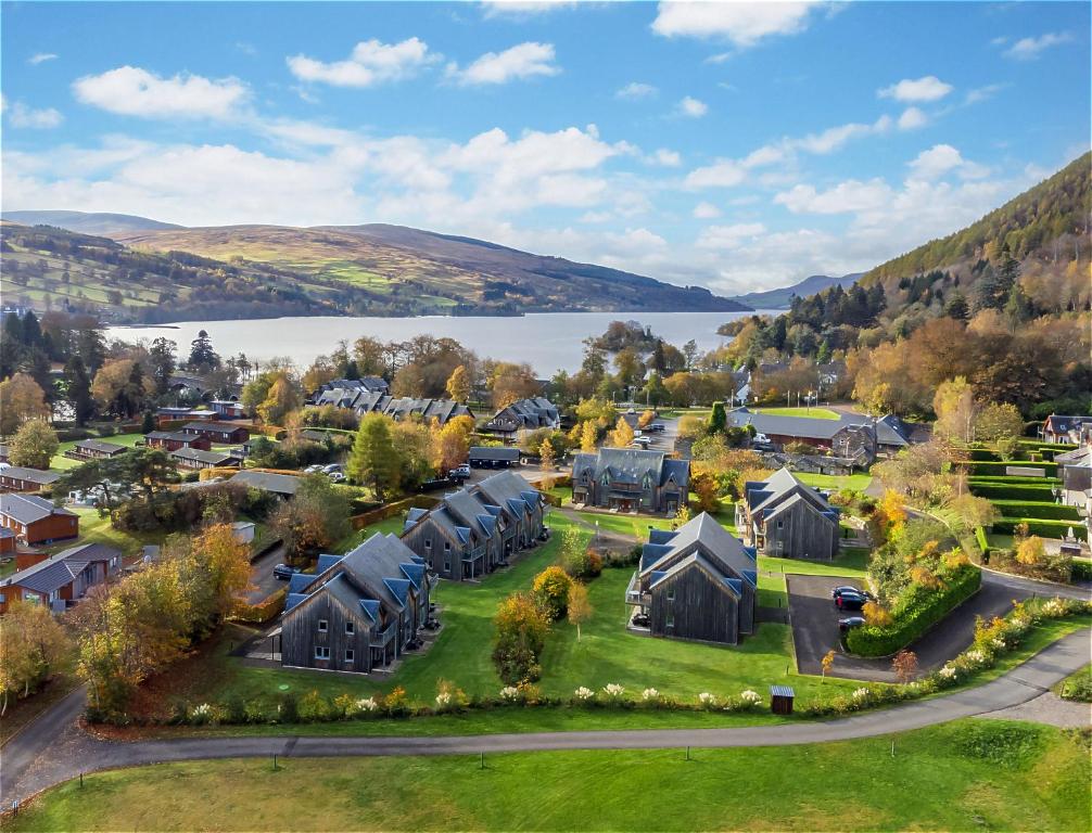 an aerial view of a village with houses and a lake at Mains of Taymouth Country Estate 4* Houses in Kenmore