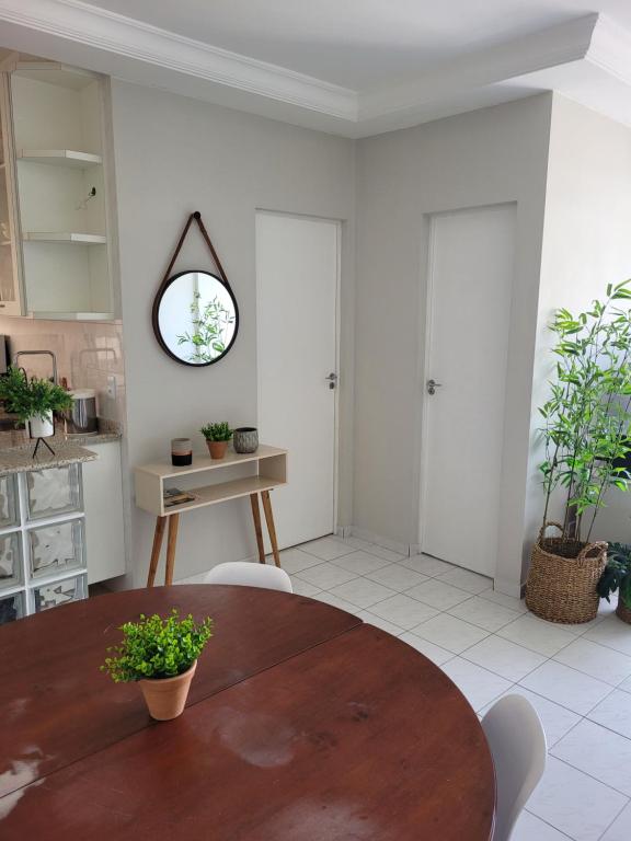 ein Esszimmer mit Tisch und Spiegel in der Unterkunft Ótimo apto Enseada Guarujá in Guarujá