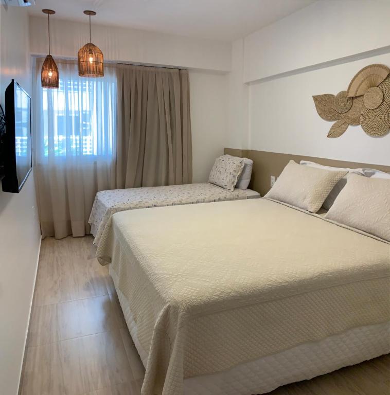 a bedroom with two beds and a window at Beach Place Cumbuco apto de 02 quartos a 80m da praia in Cumbuco
