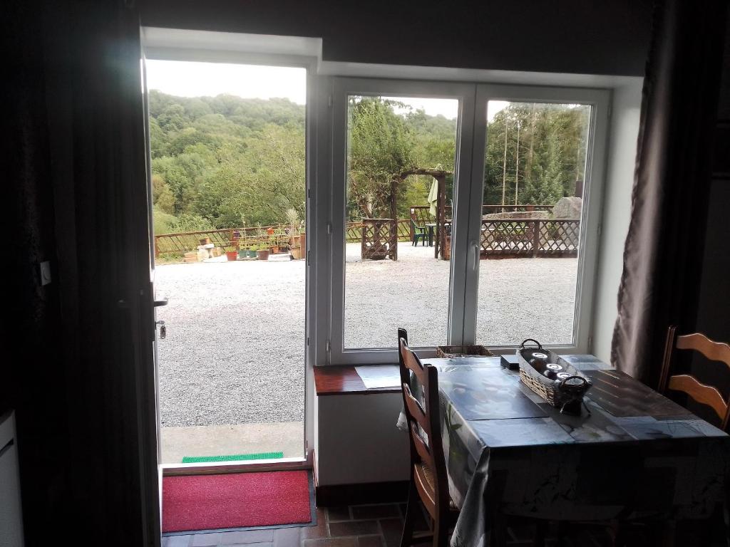 une salle à manger avec une table et une grande fenêtre dans l'établissement The House in the Woods, à Prelauff