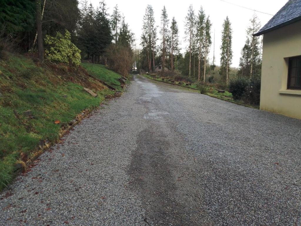 a gravel road with trees on the side of a house at The House in the Woods in Plélauff