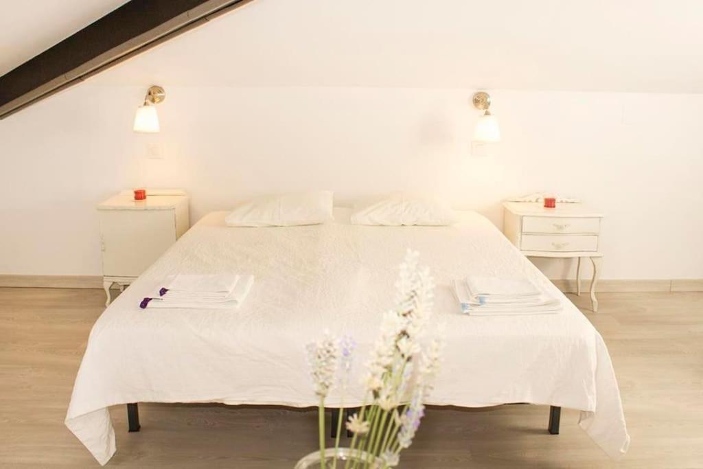 - un lit blanc dans une chambre blanche ornée de fleurs dans l'établissement Precioso estudio, à Arenas de San Pedro