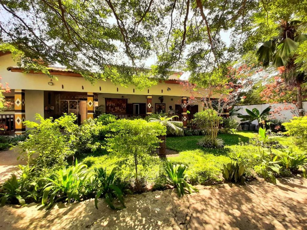a garden in front of a building with plants at Hotel Casa Sinkinling Gambia in Sere Kunda