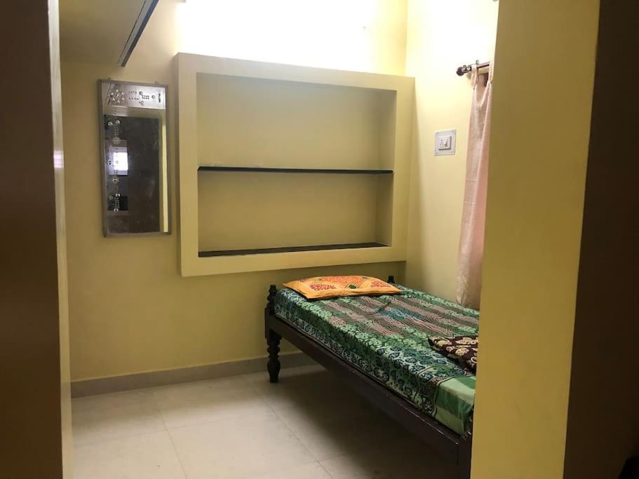 Aishwarya Nivas في بالني: غرفة صغيرة مع سرير في غرفة مع مرآة