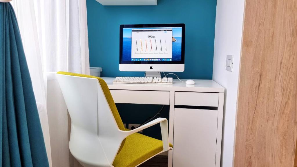 un ordenador sentado en un escritorio con una silla en Central Chic Otopeni - Self Check-in, Netflix, HBO MAX en Otopeni