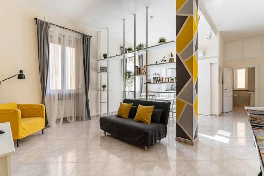 ein Wohnzimmer mit einem schwarzen Sofa und gelben Möbeln in der Unterkunft IN ROME IN LOVE IN BIKE in Rom