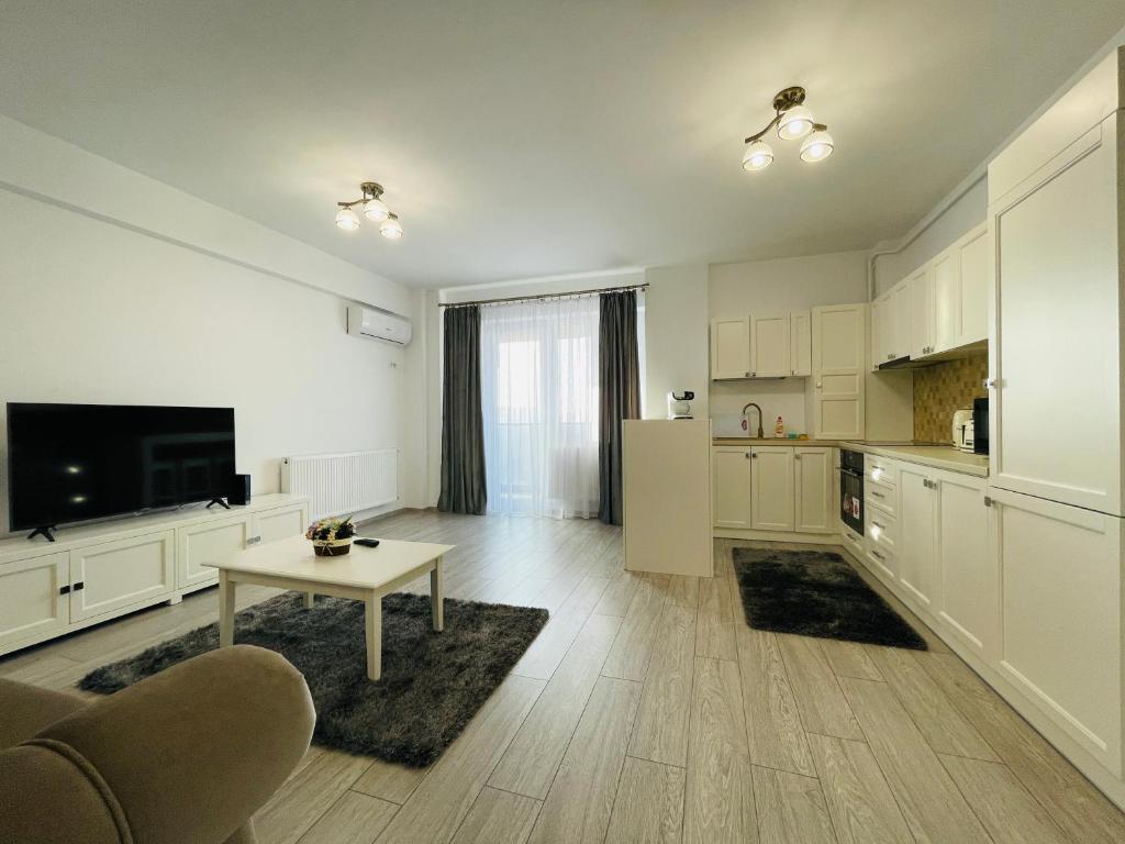uma cozinha com armários brancos e uma mesa num quarto em Luxury Apartment with Sunset View Palas em Iaşi