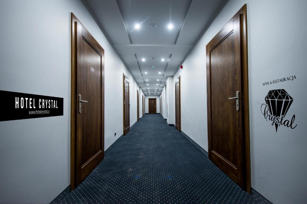 un corridoio con porte in legno e un lungo corridoio di Hotel Crystal a Janikowo
